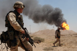 030402-N-5362A-004 Southern, Iraq (Apr. 2, 2003) -- U.S. Army Sgt. Mark Phiffer stands guard duty near a burning oil well in the Rumaylah Oil Fields in Southern Iraq. Coalition forces have successfully secured the southern oil fields for the economic future of the Iraqi people and are in the process of extinguishing the burning wells that were set ablaze in the early stages of Operation Iraqi Freedom. Operation Iraqi Freedom is the multi-national coalition effort to liberate the Iraqi people, eliminate Iraq's weapons of mass destruction and end the regime of Saddam Hussein. U.S. Navy photo by Photographer's Mate 1st Class Arlo K. Abrahamson. (RELEASED)